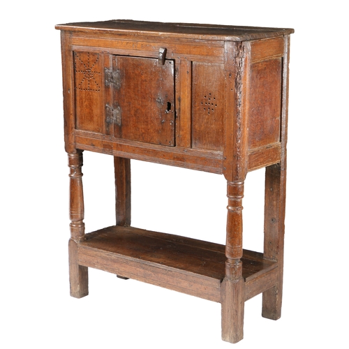 50 - AN EARLY 17TH CENTURY OAK LIVERY CUPBOARD, CIRCA 1600-30. Having a boarded top, and central boarded ... 