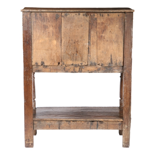 50 - AN EARLY 17TH CENTURY OAK LIVERY CUPBOARD, CIRCA 1600-30. Having a boarded top, and central boarded ... 