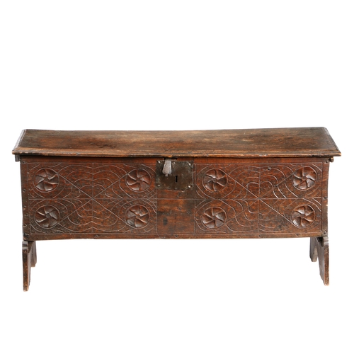 582 - A 17TH CENTURY OAK COFFER. The rectangular top with HC initials carved above a carved front panel wi... 