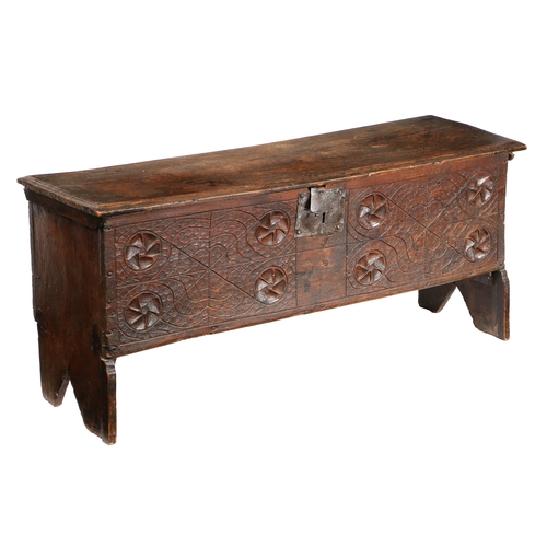 582 - A 17TH CENTURY OAK COFFER. The rectangular top with HC initials carved above a carved front panel wi... 