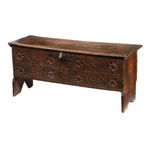 582 - A 17TH CENTURY OAK COFFER. The rectangular top with HC initials carved above a carved front panel wi... 