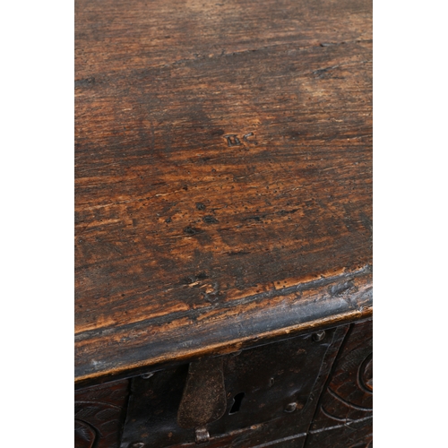 582 - A 17TH CENTURY OAK COFFER. The rectangular top with HC initials carved above a carved front panel wi... 