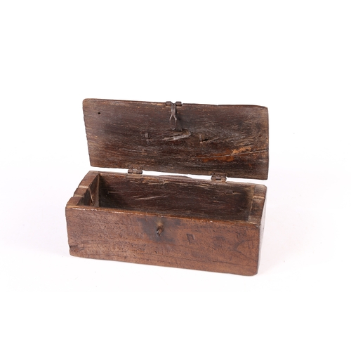 73 - AN UNUSUAL DUG-OUT BOX, POSSIBLY ELM. Having a hinged lid with iron bale handle, the base formed fro... 