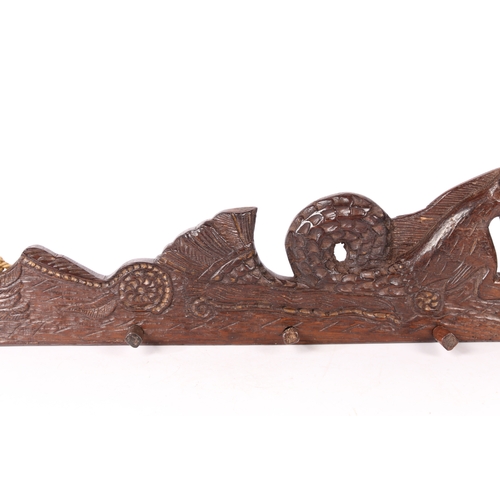 79 - A 17TH CENTURY CARVED OAK RAIL, CIRCA 1660. Designed as a hippocamp, of elongated form, with a bird ... 