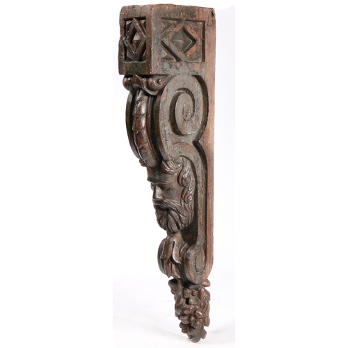 82 - A LARGE LATE 17TH CENTURY PINE AND POLYCHROME CORBEL. Carved with a male head, with full facial hair... 