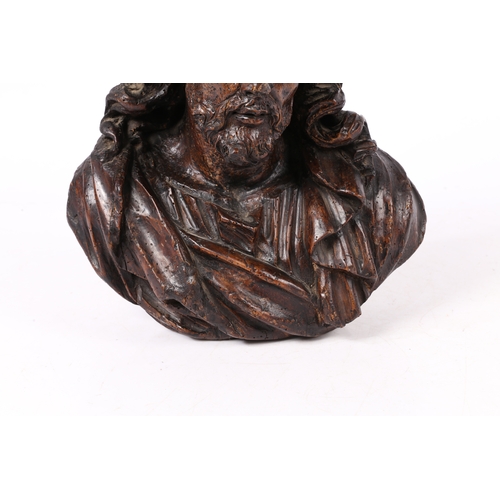 96 - A 17TH CENTURY WALNUT C ARVED BUST OF CHRIST. Flowing curled hair above wearing robes, 37cm high.