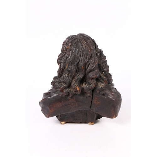 96 - A 17TH CENTURY WALNUT C ARVED BUST OF CHRIST. Flowing curled hair above wearing robes, 37cm high.