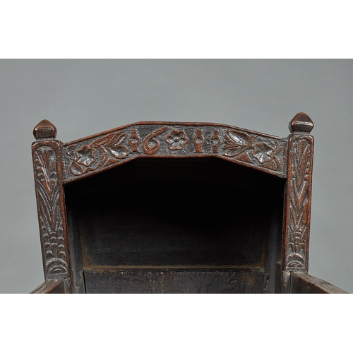 27 - A RARE AND HIGHLY UNUSUAL JAMES I OAK CRADLE, CUMBRIA, DATED 1611. The hooded cradle surmounted by f... 