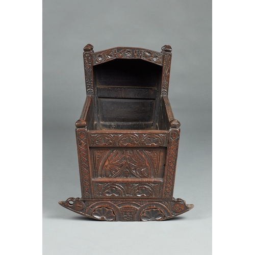 27 - A RARE AND HIGHLY UNUSUAL JAMES I OAK CRADLE, CUMBRIA, DATED 1611. The hooded cradle surmounted by f... 