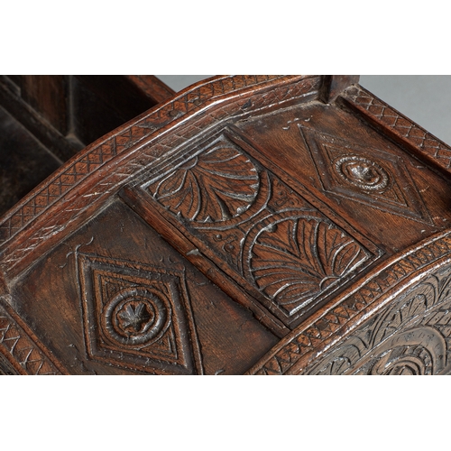 27 - A RARE AND HIGHLY UNUSUAL JAMES I OAK CRADLE, CUMBRIA, DATED 1611. The hooded cradle surmounted by f... 