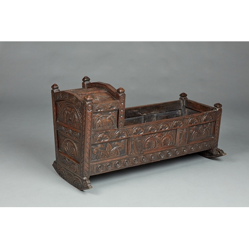 27 - A RARE AND HIGHLY UNUSUAL JAMES I OAK CRADLE, CUMBRIA, DATED 1611. The hooded cradle surmounted by f... 