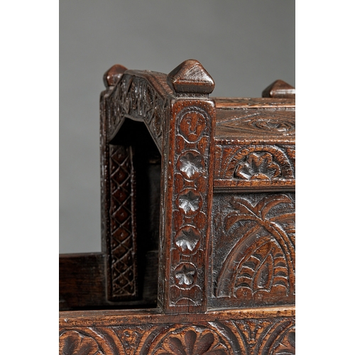 27 - A RARE AND HIGHLY UNUSUAL JAMES I OAK CRADLE, CUMBRIA, DATED 1611. The hooded cradle surmounted by f... 