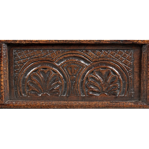 27 - A RARE AND HIGHLY UNUSUAL JAMES I OAK CRADLE, CUMBRIA, DATED 1611. The hooded cradle surmounted by f... 