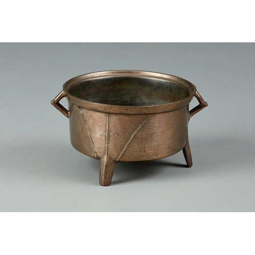 43 - AN EARLY 17TH CENTURY BRONZE TWIN HANDLE COOKING POT, ENGLISH, CIRCA 1620-1640. The circular bronze ... 