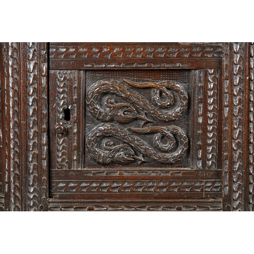 60 - AN ELIZABETH I OAK CANTED LIVERY CUPBOARD, GLOUCESTERSHIRE, CIRCA 15901600. The canted upper sectio... 