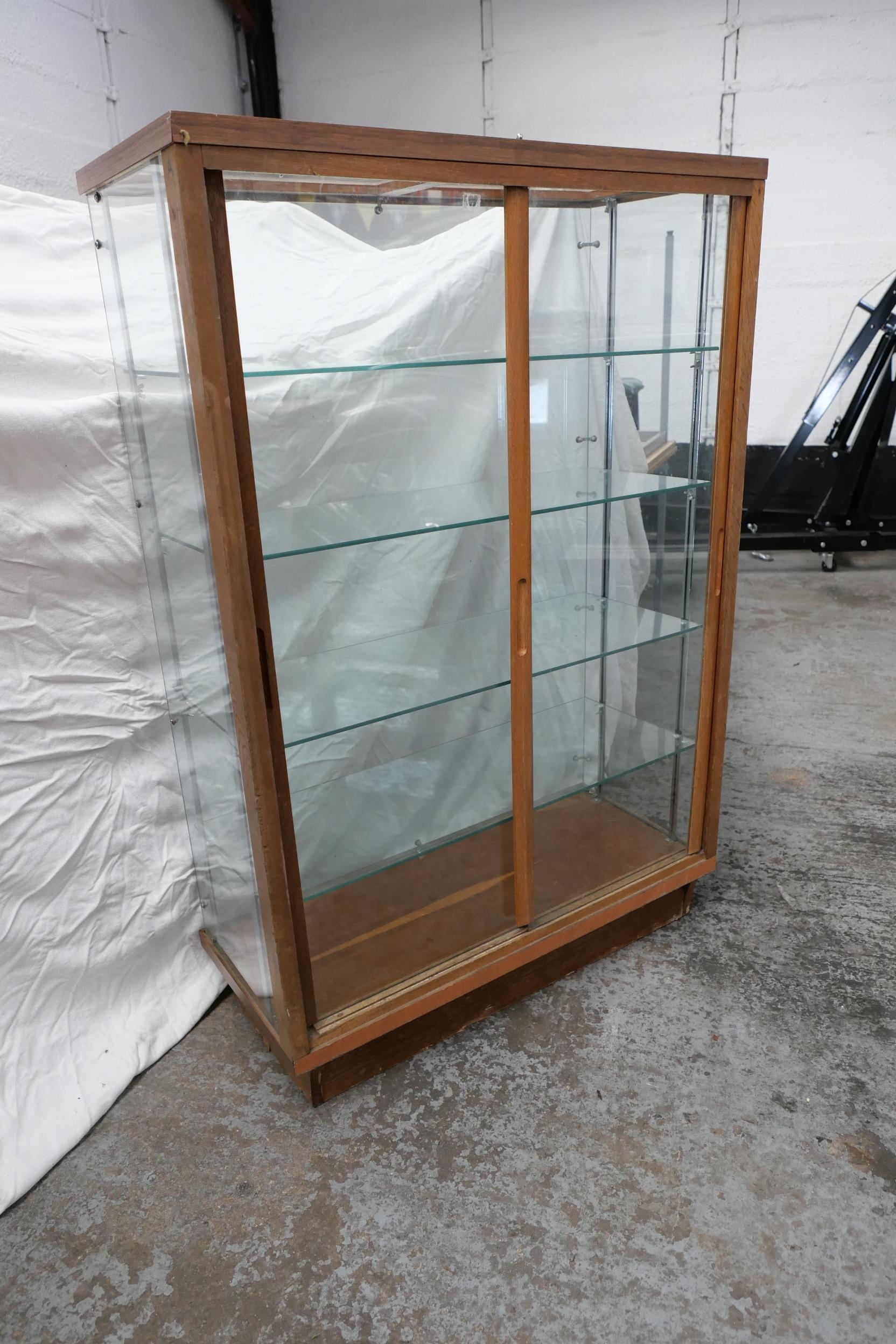 A glass display with four glass shelves, H 55 L 37 D 16 inches