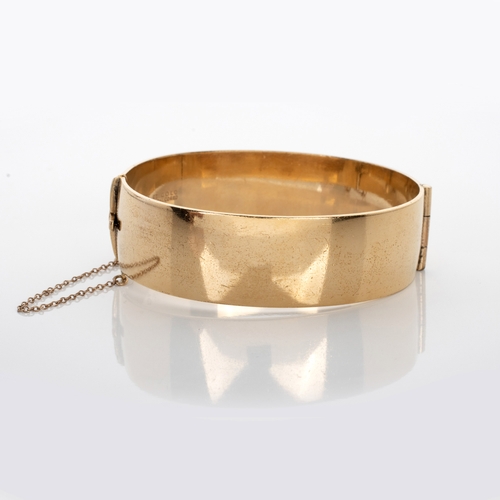 521 - A ROLLED GOLD HINGED BANGLE