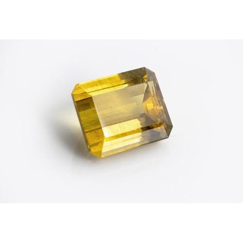 557 - AN UNMOUNTED CUT-CORNERED RECTANGULAR STEP-CUT GOLDEN APATITE