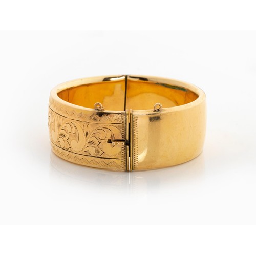 618 - A 9CT GOLD METAL-CORE HINGED BANGLE