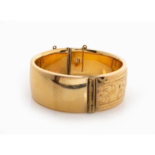 618 - A 9CT GOLD METAL-CORE HINGED BANGLE