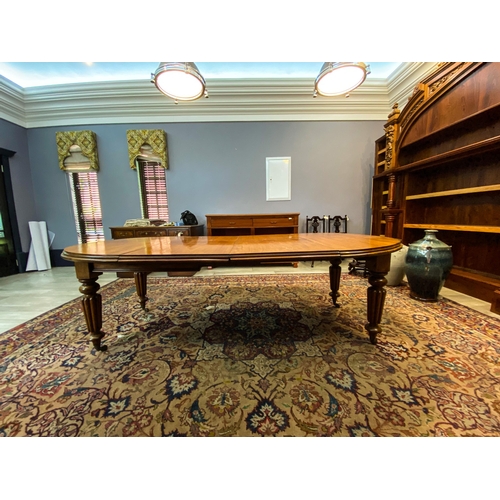 370 - A MAHOGANY EXTENDING DINING TABLE The moulded top above a plain frieze above gadrooned tapering legs... 