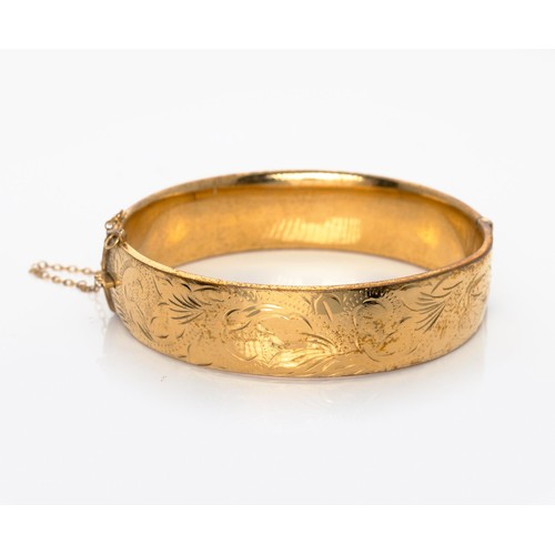 1083 - A 9CT GOLD METAL-CORE HINGED BANGLE