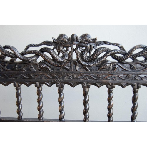 186 - AN ANGLO-INDIAN STYLE EBONISED BENCH