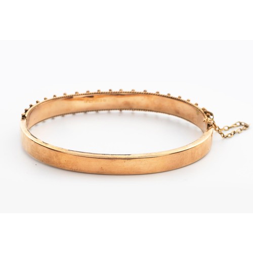 499 - A 9CT GOLD HINGED BANGLE