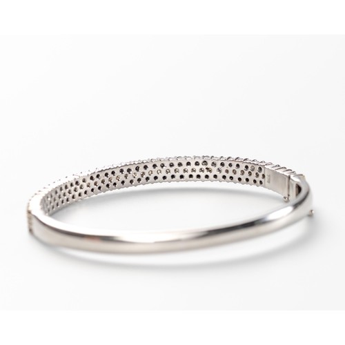 550 - A BLACK AND WHITE DIAMOND HINGED BANGLE