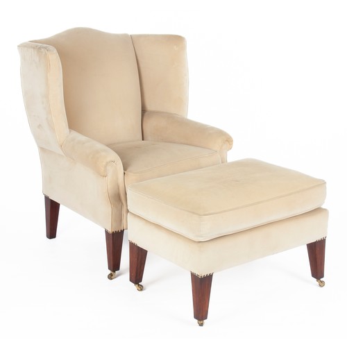 910 - AN UPHOLSTERED WINGBACK ARMCHAIR AND OTTOMAN, MODERN