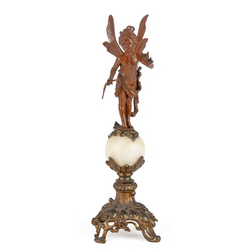 600 - A SPELTER FIGURE OF A PUTTO STANDING ON AN ORB