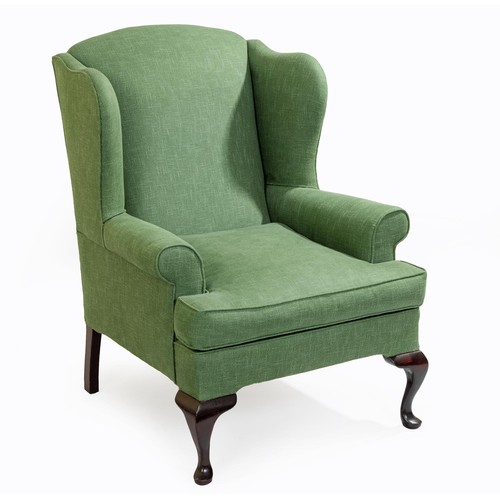 10 - AN UPHOLSTERED WINGBACK ARMCHAIR