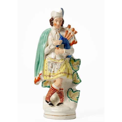 281 - A LARGE STAFFORDSHIRE FLATBACK FIGURE OF A SCOTTISH BAGPIPE PLAYER