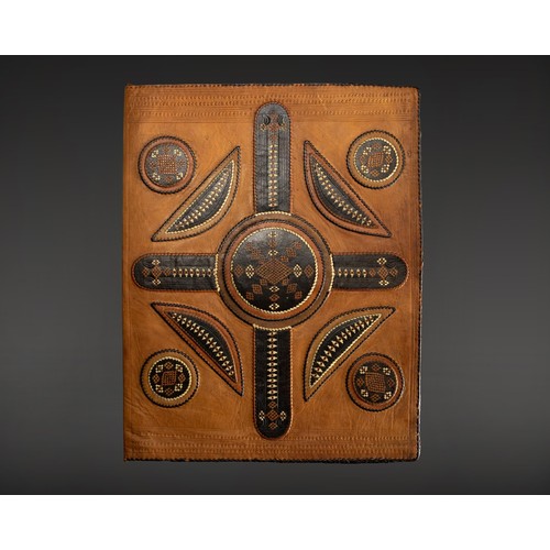 586 - A HANDCRAFTED LEATHER MANUSCRIPT COVER WITH APPLIED GEOMETRIC MOTIF