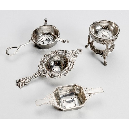 1025 - FOUR SILVER TEA STRAINERS AND A STAND, VARIOUS MAKERS AND DATES