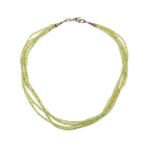 810 - A MULTI STRAND OF BEADS POSSIBLY PERIDOT GEMSTONES 