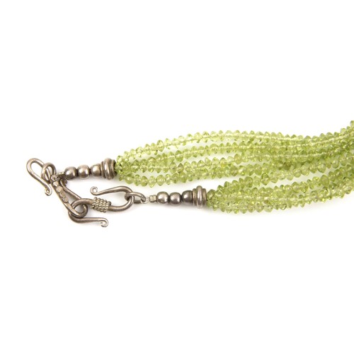 810 - A MULTI STRAND OF BEADS POSSIBLY PERIDOT GEMSTONES 