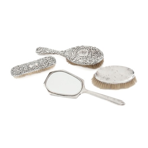 925 - A SILVER-BACKED HAND MIRROR, COMB AND PAIR OF HAIR BRUSHES