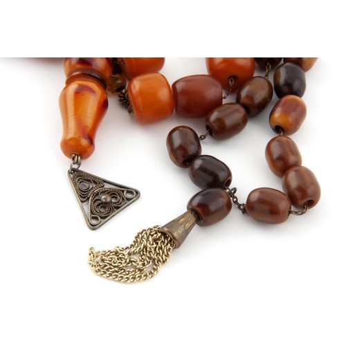 695 - A CHERRY AMBER NECKLACE AND A STRAND OF AMBER WORRY BEADS