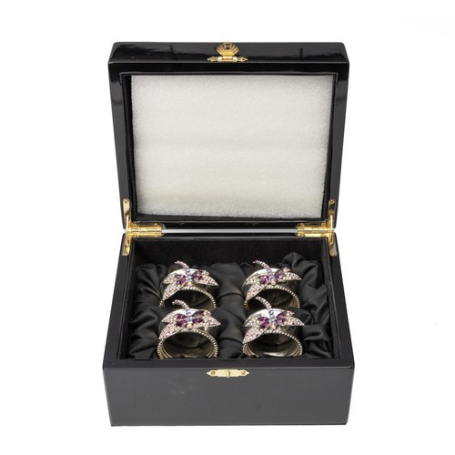 34 - A CASED SET OF FOUR RHODIUM-COATED NAPKIN RINGS, ISABELLA ADAMS