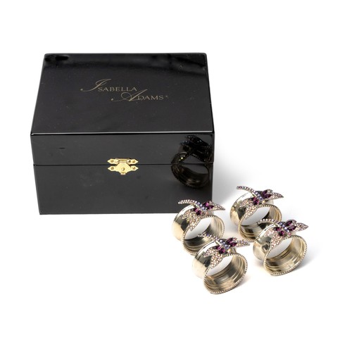 34 - A CASED SET OF FOUR RHODIUM-COATED NAPKIN RINGS, ISABELLA ADAMS