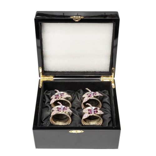 35 - A CASED SET OF FOUR RHODIUM-COATED NAPKIN RINGS, ISABELLA ADAMS
