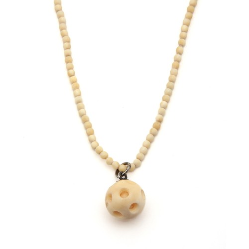 743 - A BEADED TUSK NECKLACE WITH CHINESE PUZZLE BALL PENDANT