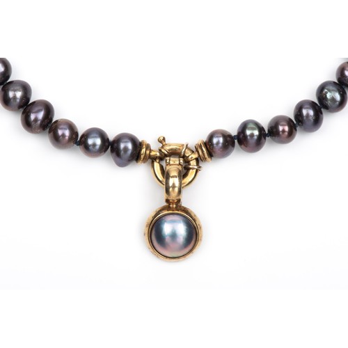 80 - A STRAND OF FRESHWATER BLACK PEARLS WITH ENHANCER