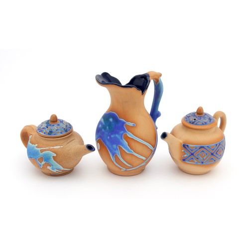 693 - TWO CERAMIC TERRACOTTA AND GLAZE TEAPOTS AND A JUG