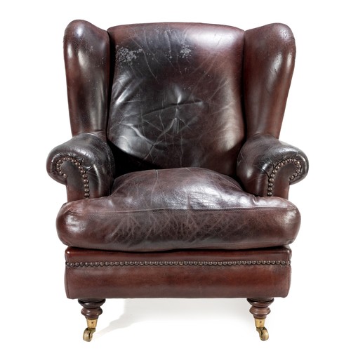 253 - A LEATHER WINGBACK ARMCHAIR