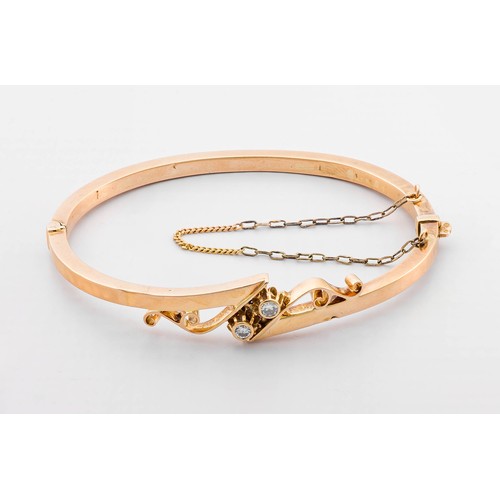 702 - A GOLD AND DIAMOND HINGED BANGLE