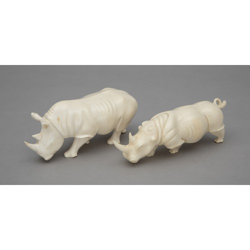 48 - A PAIR OF CARVED TUSK RHINO FIGURINES, ONE SIGNED 'P.K'