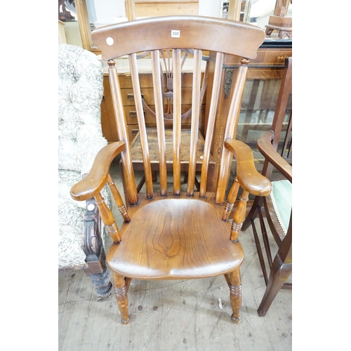 332 - An elm seat slat backed armchair (lowered)