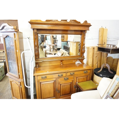 214 - An Arts and Crafts style walnut mirror backed dresser with fielded panelled doors, brass handles, be... 